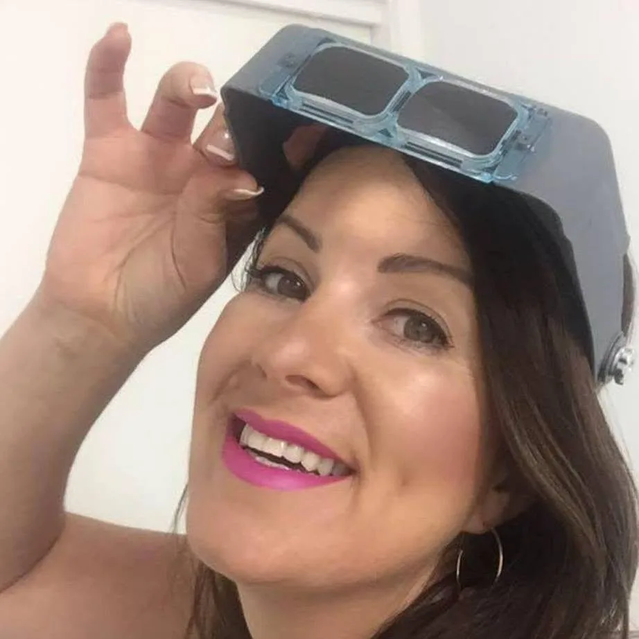 Simone Carter — smiling selfie with a welding-style visor prop and pink lip